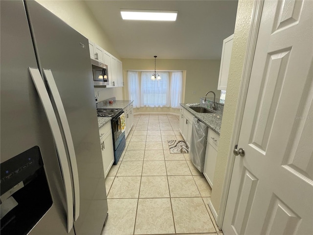 kitchen with light stone counters, stainless steel appliances, sink, pendant lighting, and white cabinets