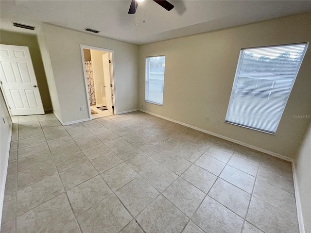 unfurnished bedroom with ensuite bath, ceiling fan, and light tile patterned floors