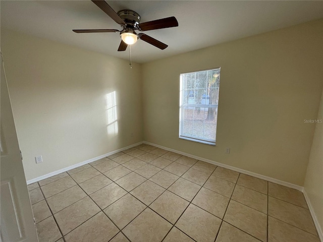 tiled spare room featuring ceiling fan