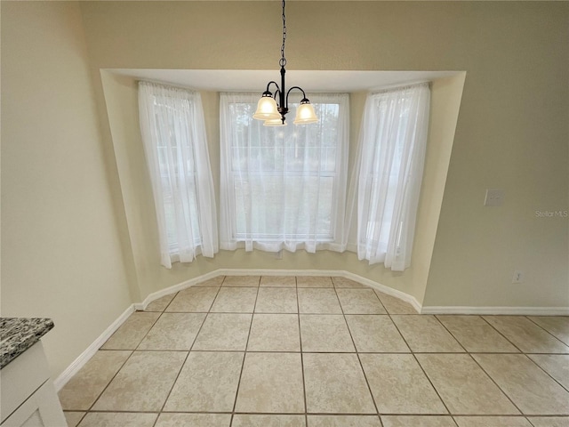 unfurnished dining area with light tile patterned floors and an inviting chandelier