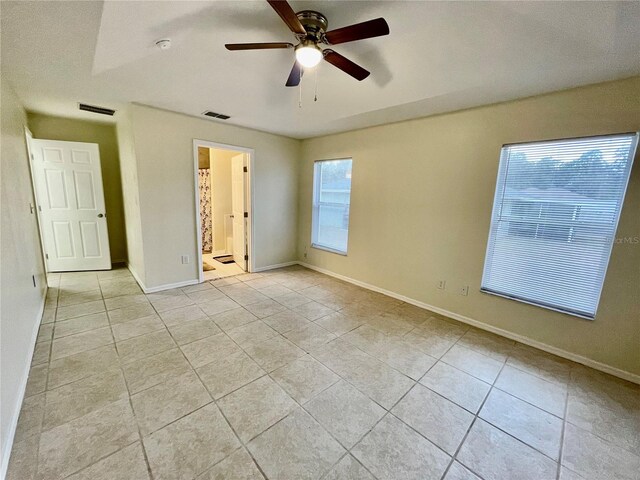 spare room with ceiling fan and light tile patterned flooring