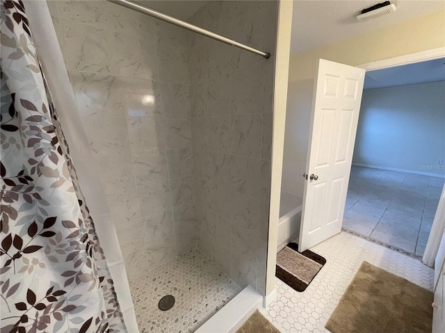 bathroom with curtained shower and tile patterned flooring