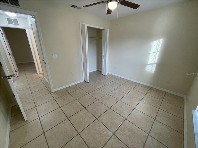 unfurnished bedroom featuring ceiling fan, light tile patterned floors, and a closet