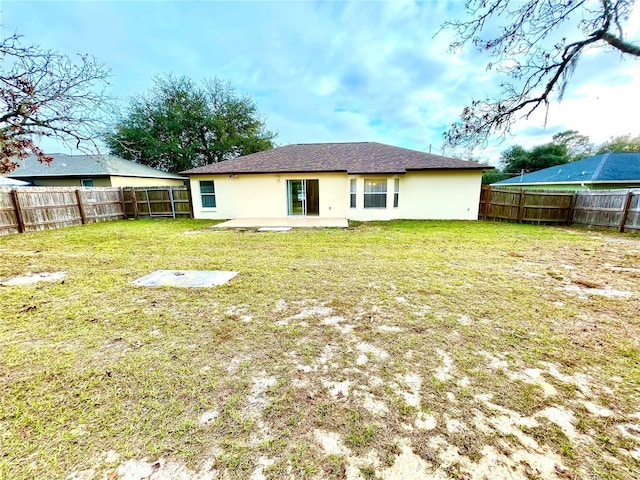 back of property with a lawn and a patio