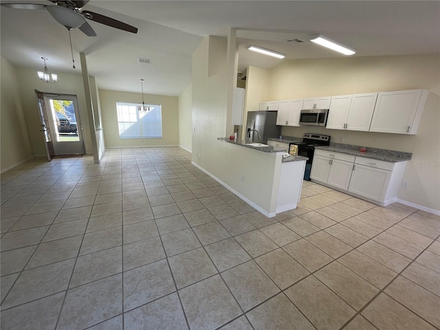 kitchen featuring stainless steel appliances, white cabinets, lofted ceiling, light tile patterned floors, and ceiling fan with notable chandelier