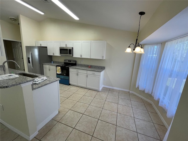 kitchen with pendant lighting, lofted ceiling, an inviting chandelier, white cabinets, and appliances with stainless steel finishes