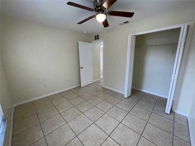 unfurnished bedroom with light tile patterned floors, a closet, and ceiling fan