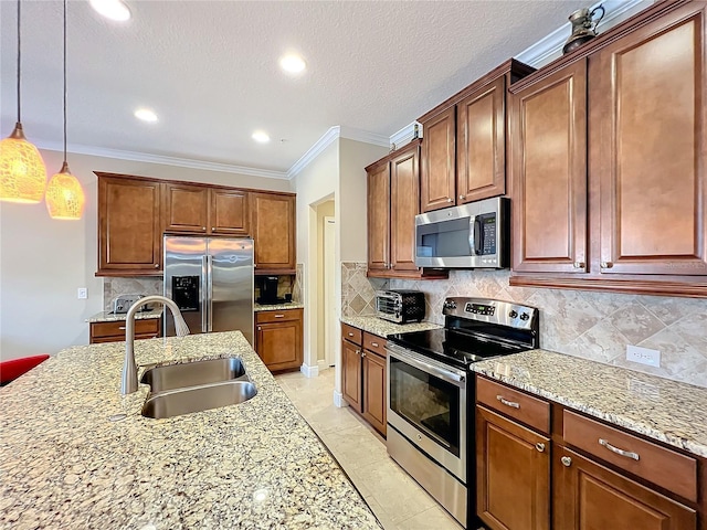 kitchen with backsplash, crown molding, sink, hanging light fixtures, and stainless steel appliances