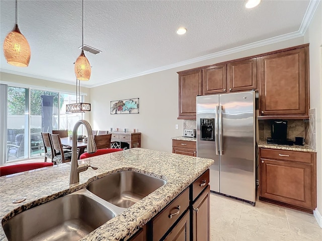 kitchen with sink, stainless steel refrigerator with ice dispenser, ornamental molding, a textured ceiling, and decorative light fixtures