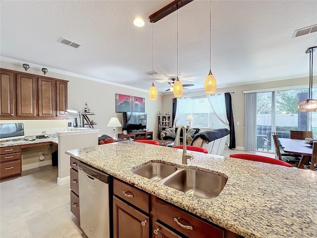 kitchen with pendant lighting, dishwasher, light stone counters, and sink