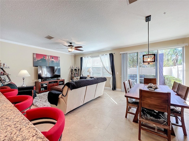 living room with a textured ceiling, ceiling fan, and crown molding