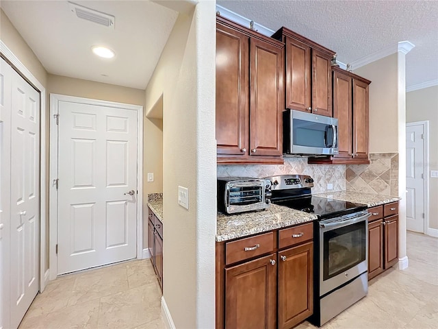 kitchen with tasteful backsplash, light stone counters, a textured ceiling, stainless steel appliances, and crown molding