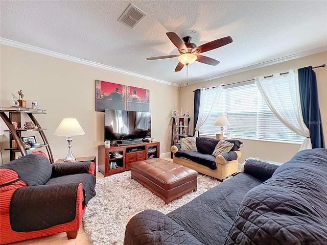 living room with a textured ceiling, ceiling fan, and crown molding