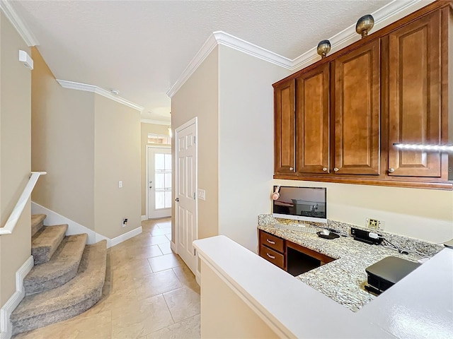 kitchen featuring light stone countertops, light tile patterned floors, and ornamental molding