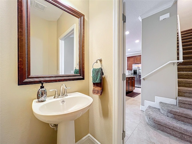 bathroom featuring ornamental molding and sink