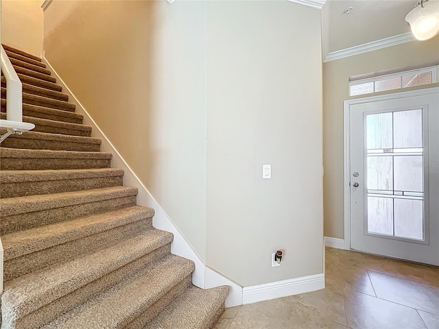 tiled foyer entrance featuring ornamental molding