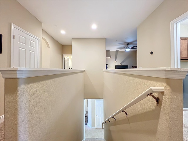 stairway featuring ceiling fan