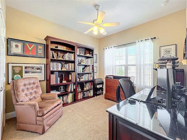 carpeted office featuring a textured ceiling and ceiling fan