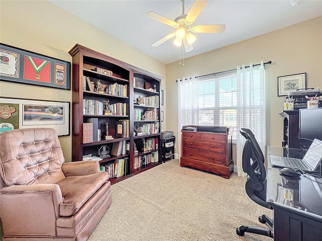 carpeted home office with ceiling fan and a textured ceiling