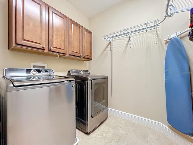 washroom featuring cabinets and independent washer and dryer