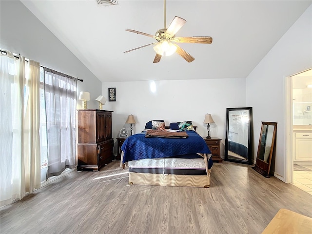 bedroom with ceiling fan, lofted ceiling, light hardwood / wood-style flooring, and ensuite bath