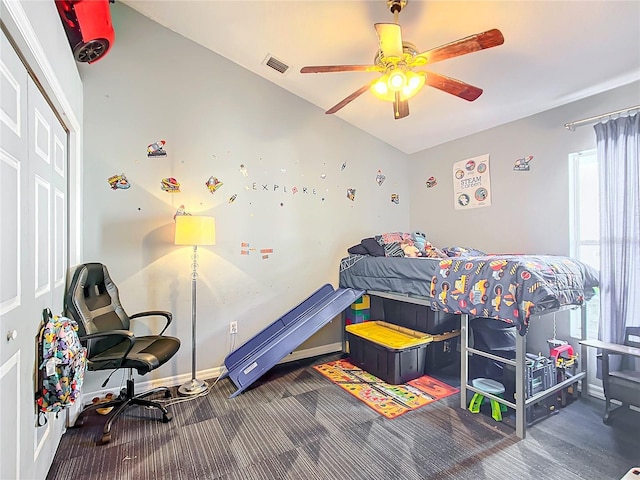 bedroom featuring dark colored carpet, ceiling fan, and a closet