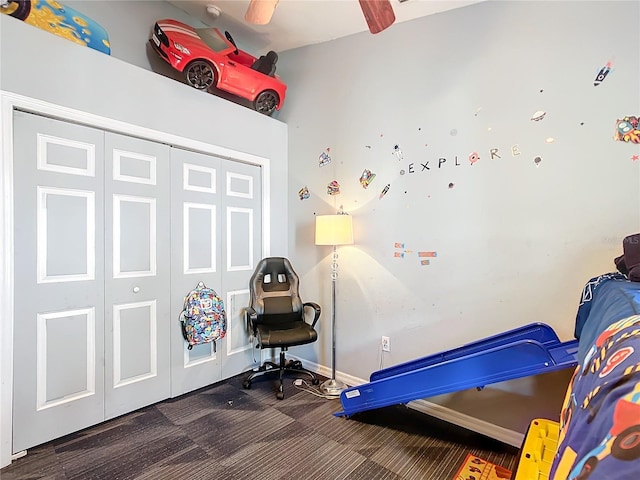 bedroom featuring dark colored carpet, a closet, and ceiling fan