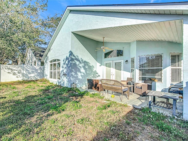 rear view of house featuring outdoor lounge area, ceiling fan, a patio, and a lawn