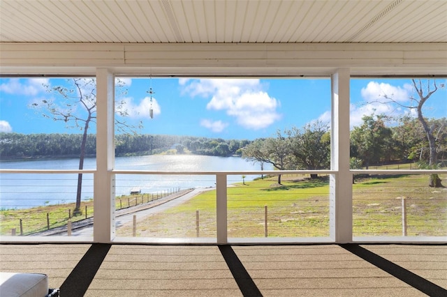 unfurnished sunroom featuring a water view