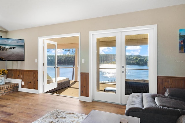 doorway to outside featuring french doors, a water view, and a wealth of natural light