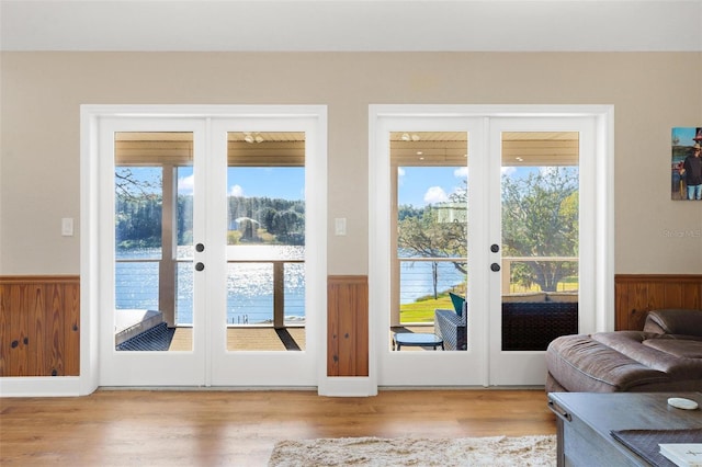 entryway featuring french doors, a water view, and plenty of natural light