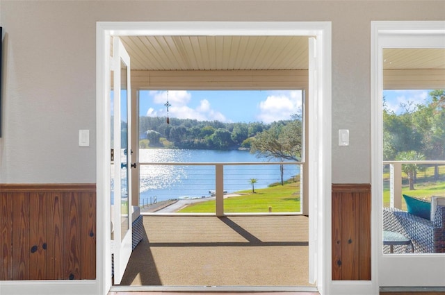 doorway to outside with wooden walls and a water view