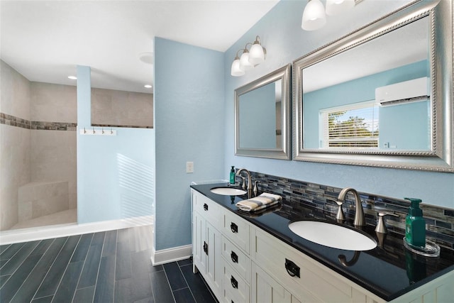 bathroom with vanity, a tile shower, a wall unit AC, and tasteful backsplash