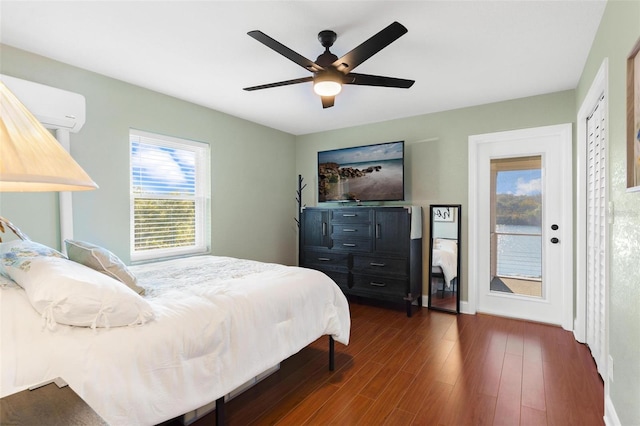 bedroom with access to exterior, dark hardwood / wood-style floors, an AC wall unit, and ceiling fan