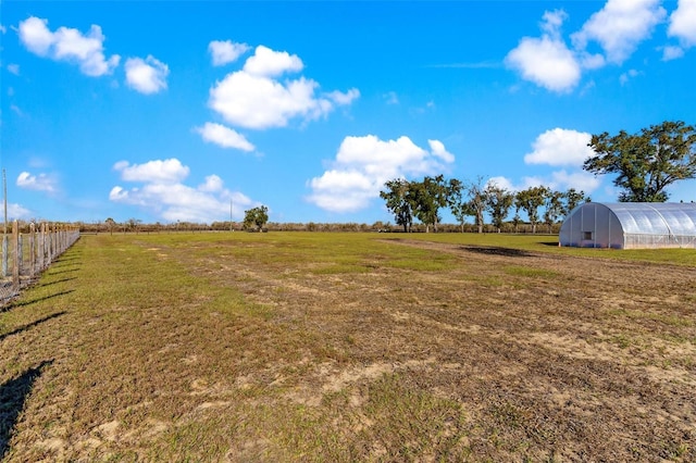 view of yard with a rural view and an outdoor structure