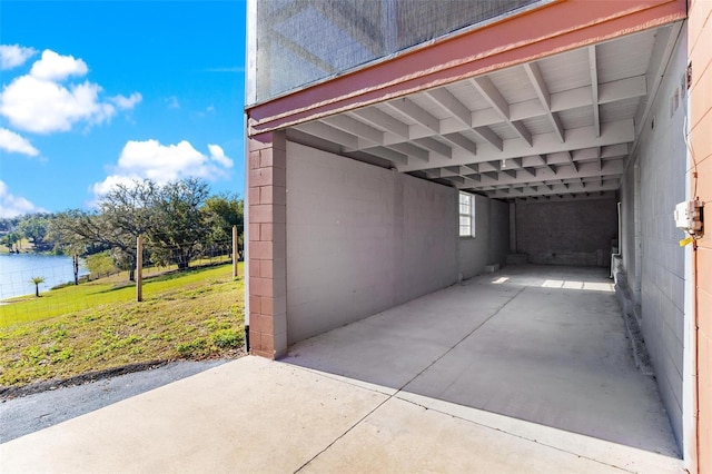 view of car parking with a water view and a carport