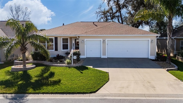 ranch-style home with driveway, roof with shingles, a garage, and a front yard