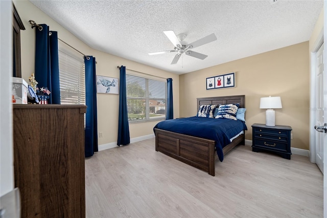 bedroom featuring a textured ceiling, ceiling fan, and light hardwood / wood-style flooring