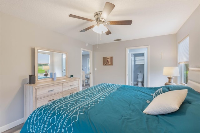 bedroom featuring a textured ceiling, connected bathroom, ceiling fan, and multiple windows