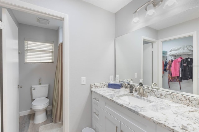 bathroom with wood-type flooring, vanity, and toilet