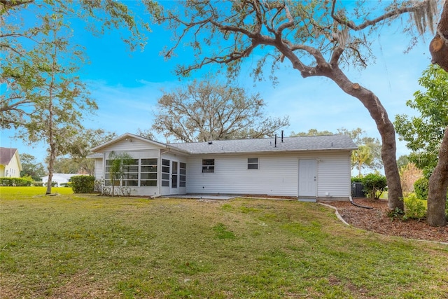 rear view of house featuring a sunroom and a yard