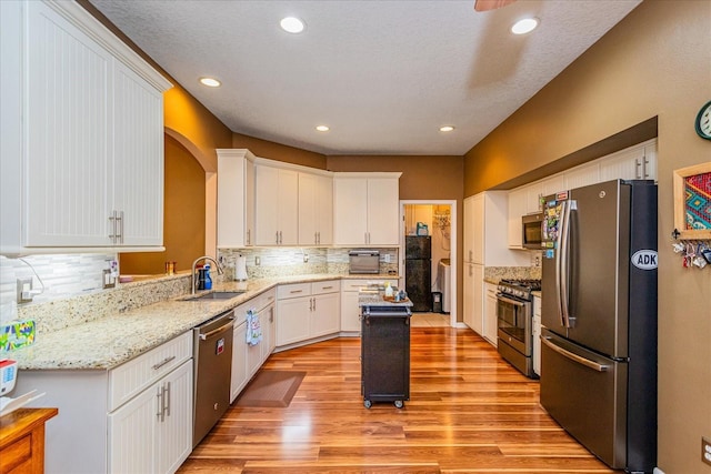 kitchen featuring light hardwood / wood-style flooring, stainless steel appliances, white cabinetry, and sink