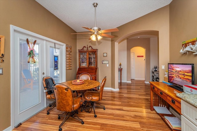 dining area featuring ceiling fan, french doors, light hardwood / wood-style floors, and a textured ceiling