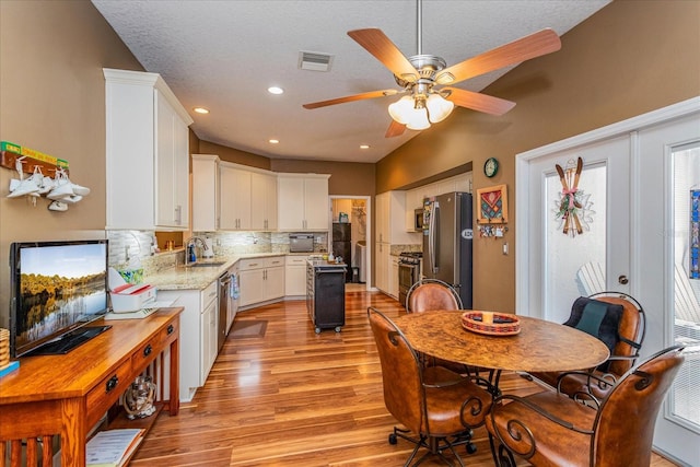 kitchen featuring white cabinetry, sink, ceiling fan, stainless steel appliances, and tasteful backsplash