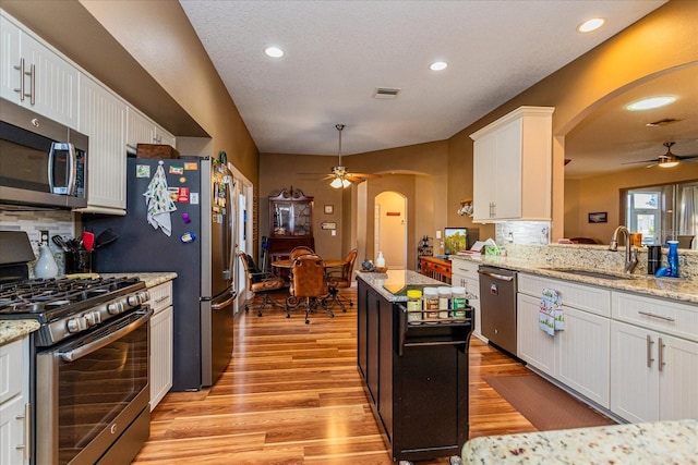 kitchen with white cabinets, appliances with stainless steel finishes, tasteful backsplash, and sink