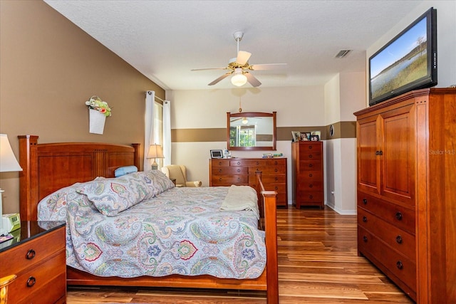 bedroom featuring a textured ceiling, light wood-type flooring, and ceiling fan