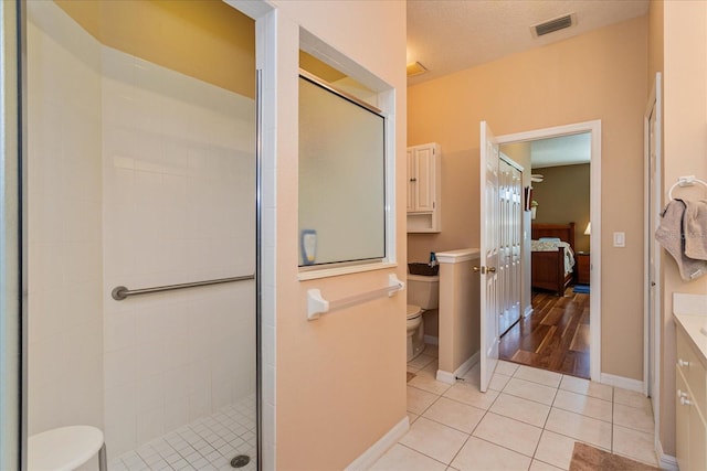 bathroom with walk in shower, tile patterned flooring, vanity, and toilet