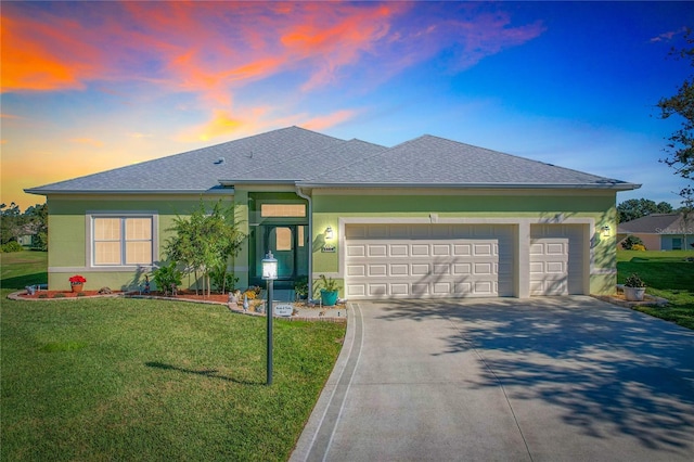 view of front of property with a garage and a lawn