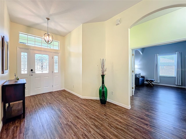 foyer entrance with dark wood-type flooring and an inviting chandelier