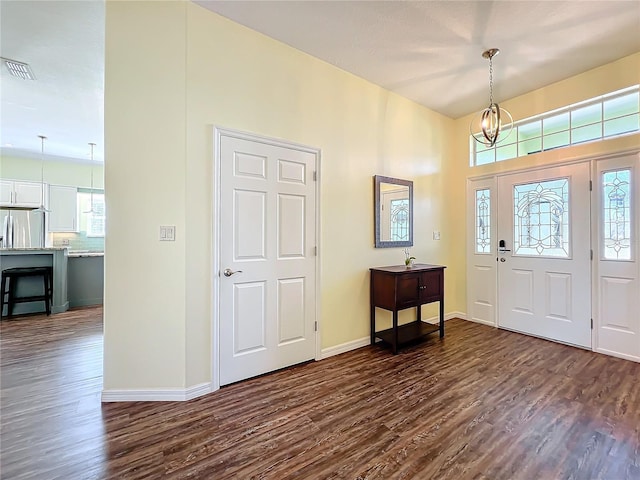 foyer entrance featuring dark wood-type flooring and a notable chandelier